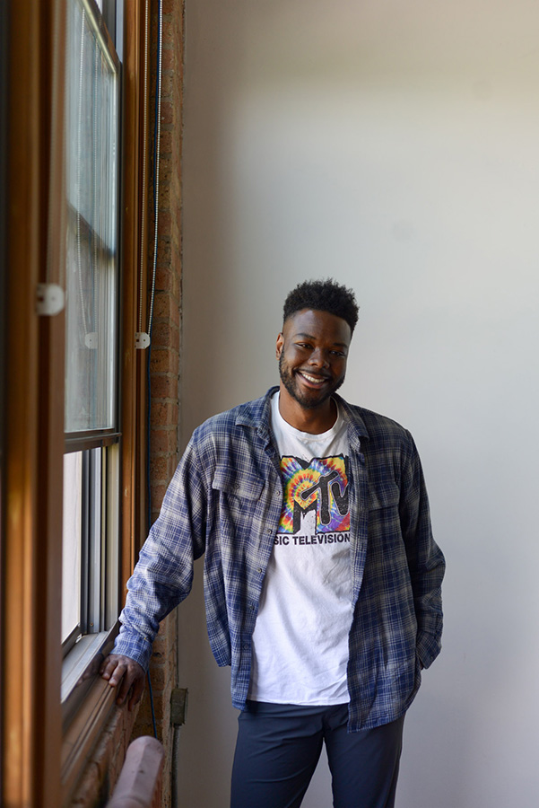 A portrait of Peter Catchings posing by a big window. 